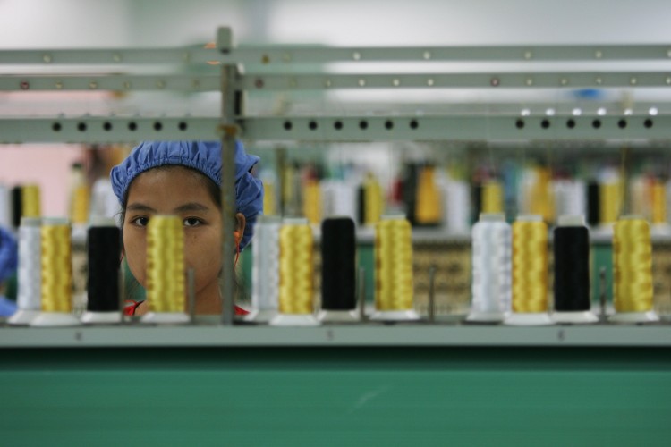 A worker labors before the spinning machine at the production line of Dongguan Da Lang Wealthwise Plastic Factory on Sept. 4, 2007 in Dongguan, Guangdong Province. The recent closing of Dingjia Knitting Company has caused growing fears of widespread bankruptcy in the area. (Feng Li/Getty Images)
