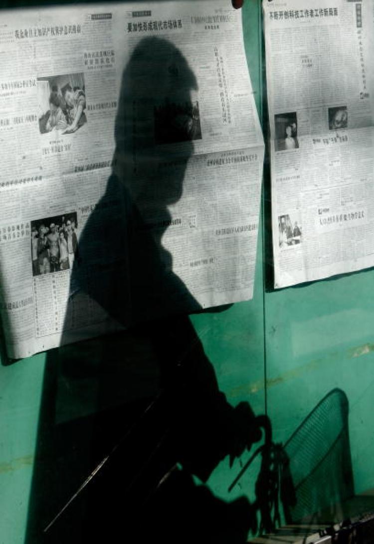 A shadow of a cyclist is reflected on newspaper bulletin boards along a street in Beijing. (Teh Eng Koon/AFP/Getty Images)