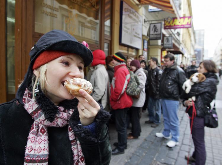 A girl eats a 'paczek,' a popular doughnut like pastry from Poland, as other customers queue in front of a pastry shop in Warsaw on 'Fat Thursday', ahead of the Christian period of Lent last January 2008. (Janek Skarzynski/Getty Images )