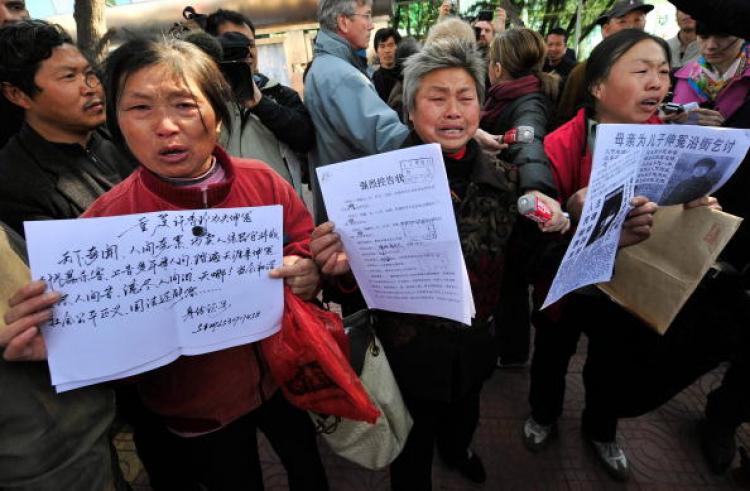 Agitated Chinese petitioners show documents during a gathering outside a courthouse, at the time that human rights activist Hu Jia was in attendance inside the court, in Beijing. (Teh Eng Koon/AFP/Getty Image)