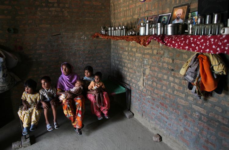 An Indian farmer sits with her children in the village of Bhatuan, 150km west of Chandigarh. Her husband committed suicide in in November 2007 due to debt. (Pedro Ugarte/AFP/Getty Images)