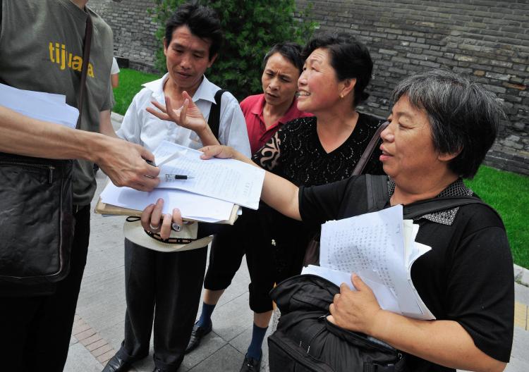 July 2, 2008 Chinese petitioners show their documents listing their grievances to a reporter near a petition office in Beijing. (Teh Eng Koon/AFP/Getty Images)