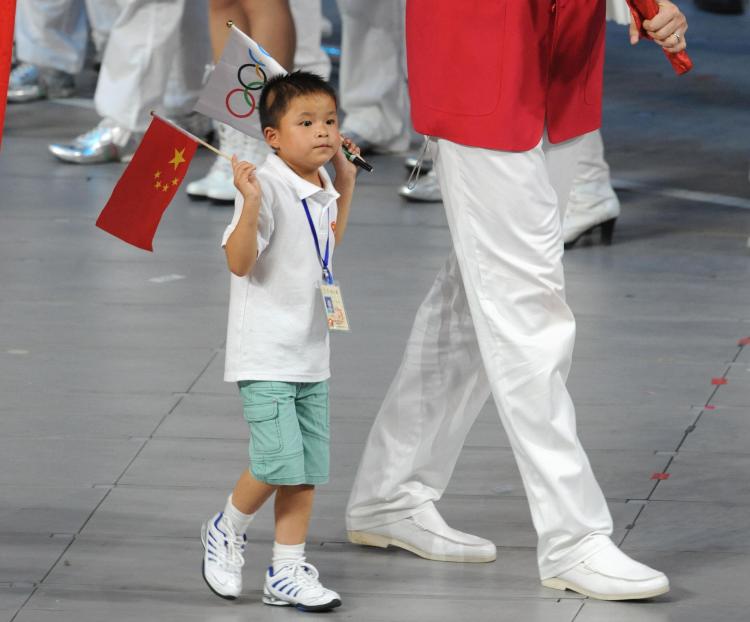 A young boy holds an upside down China flag during the opening ceremony for the Olympic Games in Beijing. (Saeed Kahn/AFP/Getty Images)