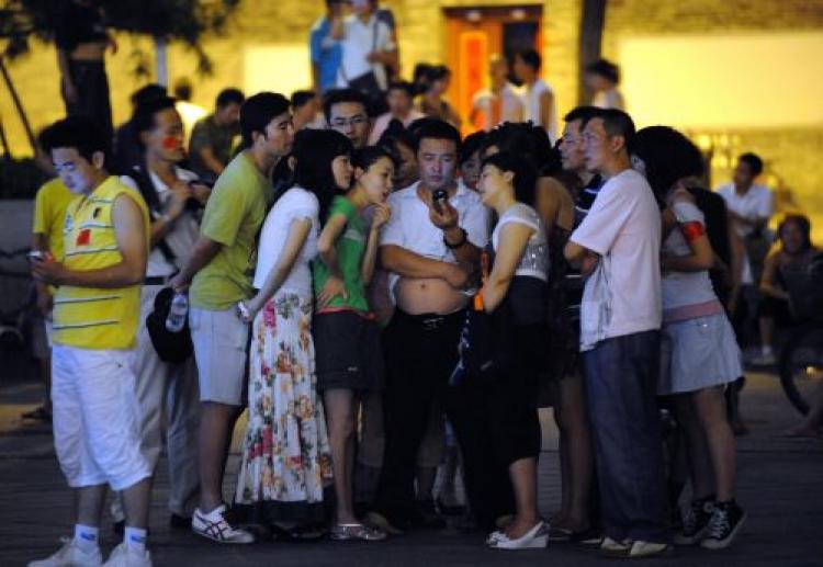 Chinese residents gather around to watch the Beijing Olympics in Beijing.  (Goh Chai Hin/AFP/Getty Images)