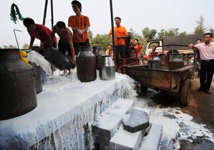 Farmer workers pour away uncollected milk at a farm in Wuhan of Hubei Province, China. (China Photos/Getty Images)