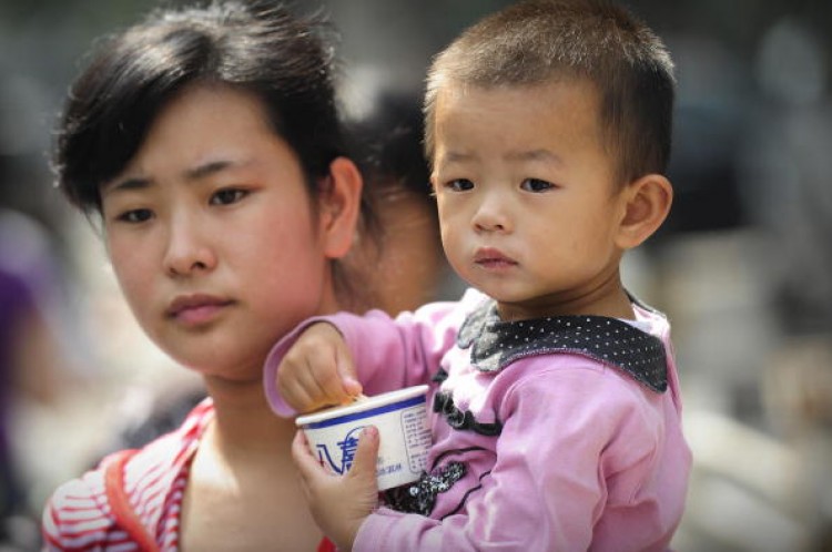 A mother leaves a children's hospital with her child in Beijing on September 22, 2008 as China's toxic milk scandal escalated after officials admitted nearly 53,000 children had been sickened by contaminated products and more countries moved to ban or lim (Peter Parks/AFP/Getty Images)