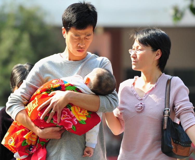 Parents and their baby leave a children's hospital in Beijing on October 16, 2008. Lawyers for victims of China's tainted milk scandal said the government had warned them not to sue.  (Frederic J Brown/AFP/Getty Images)