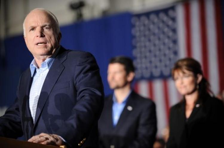 Republican presidential candidate John McCain speaks at a campaign rally in an airplane hangar at the airport in Cincinnati, Ohio on Oct. 22, 2008. At right are his running mate Sarah Palin and her husband Todd.  (Robyn Beck/AFP/Getty Images)