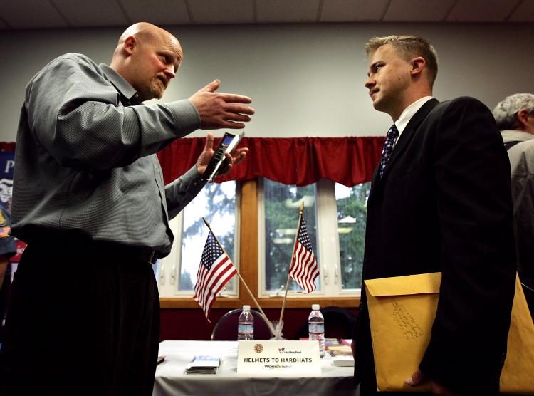 A participant talks to a representative of Helmets to Hardhats at a job fair for veterans and active-duty military job seekers in Redmond, Washington.  (Robert Giroux/Getty Images)