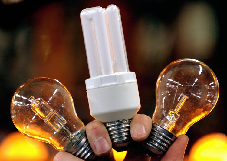 IKEA phases out incandescent light bulbs. Energy-saving light bulbs (C and L) next to an incandescent one (R). (Frederick Florin/AFP/Getty Images)