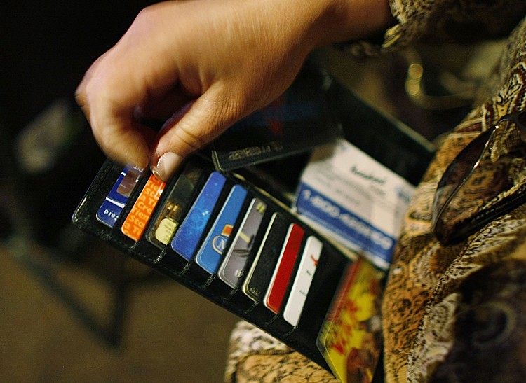 Ileana Garcia looks in her wallet for credit cards she wants to melt over a hot plate as she tries to dig herself out of credit card debt during a sermon by Kevin Cross about faith-based financial management at the Miami Vineyard Community Church on March 7, 2009 in Kendall, Florida. (Joe Raedle/Getty Images)