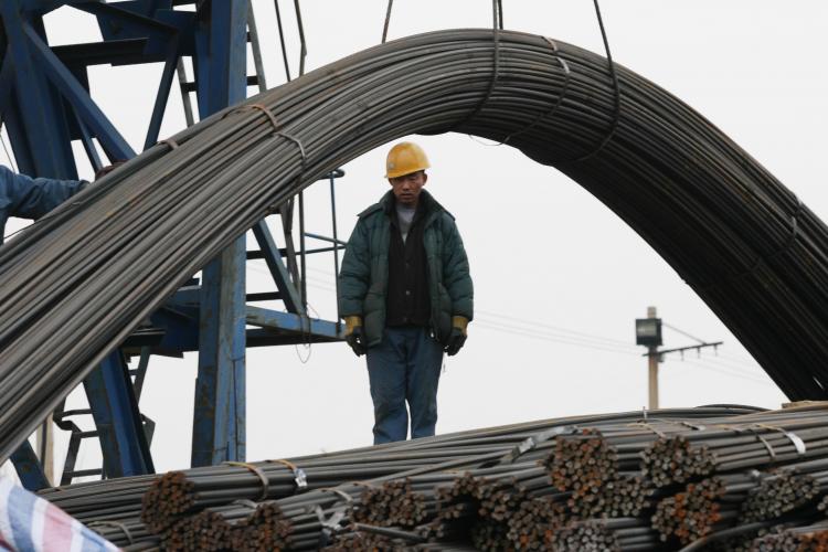 A worker works to load steel on a truck at a steel wholesale market on March 12, 2009, in Shenyang of Liaoning Province, China.  (China Photos/Getty Images)