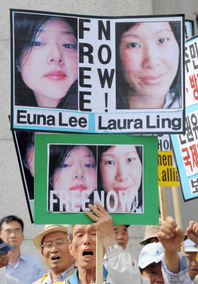 A South Korean conservative activist holds pictures of U.S. journalists Euna Lee (L) and Laura Ling (R) during a rally denouncing North Korea's detention of the journalists in Seoul.  (Jung Yeon-je/AFP/Getty Images)