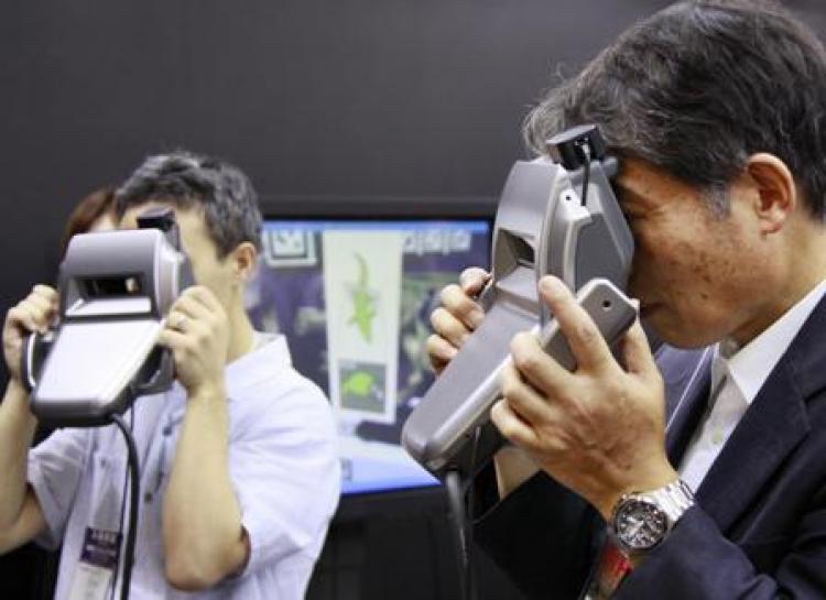 Visitors look at a mixed reality world. (Yoshikazu Tsuno/Getty Images)
