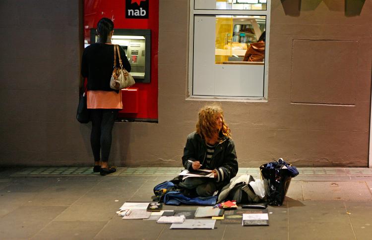 A woman sits on the pavement as a woman behind her withdraws money from an ATM machine on Aug. 31, 2009, in Melbourne, Australia. During the coming CEO Sleep-out event, CEOs will camp out for a night on Australia's streets. (Scott Barbour/Getty Images) A woman sits on the pavement as a woman behind her withdraws money from an ATM machine on Aug. 31, 2009, in Melbourne, Australia. During the coming CEO Sleep-out event, CEOs will camp out for a night on Australia's streets. (Scott Barbour/Getty Images)