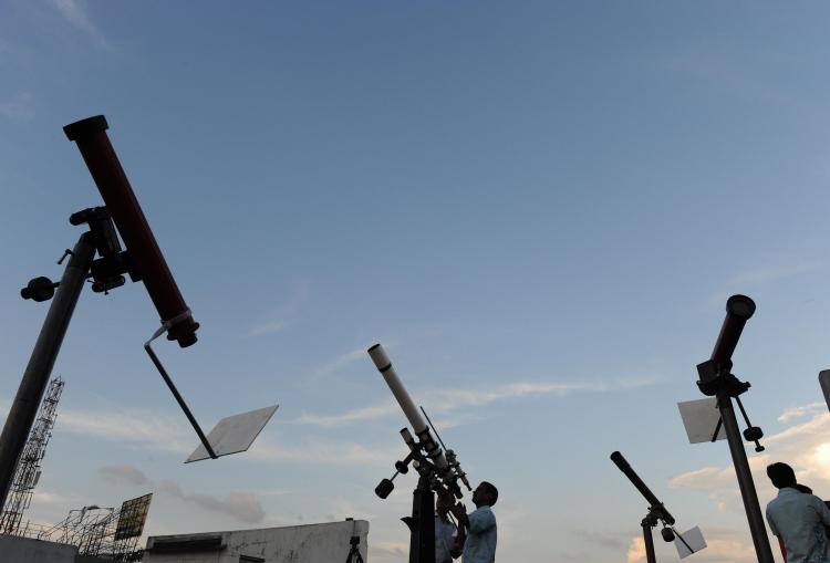 Indian sky watchers set up their telescopes on a roof top of a science center in Patna, on July 21, 2009, on the eve of a total eclipse of the sun.  (Deshakalyan Chowdhury/AFP/Getty Images)