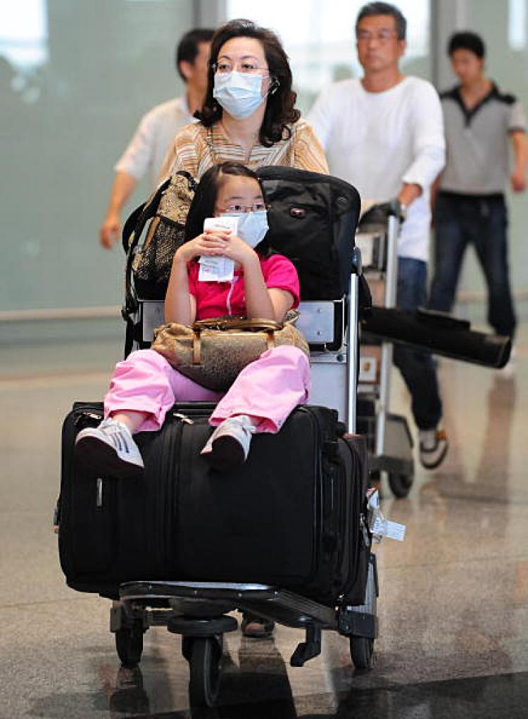 Passengers at the Beijing International Airport wear protective masks for fear of the H1N1 flu. (Getty Images)