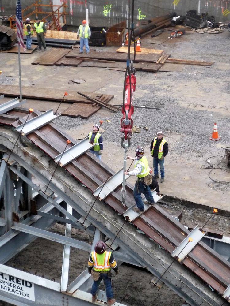 Crews lifted a historical set of stairs up and out of its temporary storage at the World Trade Center site on Thursday. The stairs allowed many to escape the collapsing towers on 9/11. (Christine Lin/The Epoch Times)