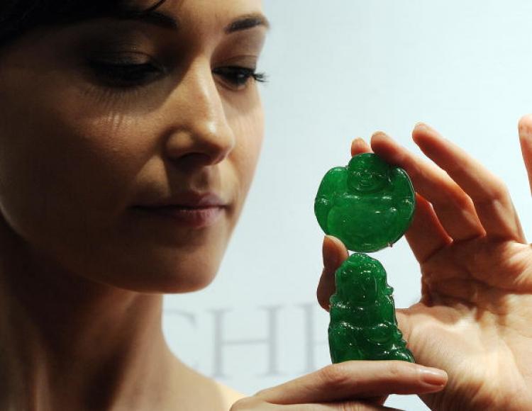 A carved jadeite Milefo valued between 770,000 to 1 million US dollars and a jadeite Guanyin in Hong Kong. (Mike Clarke/AFP/Getty Images)