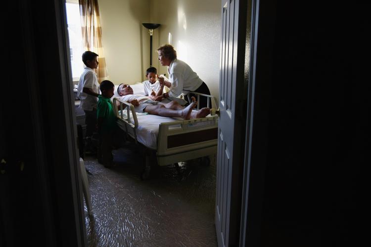 Registered nurse Susan Eager explains to the sons of Carlos Granillo, 31, how to help care for their injured father at their home on November 9, 2009 in Denver, Colorado. (John Moore/Getty Images)