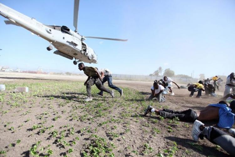 Haitians rush to pick up water just dropped from a Navy helicopter as help continues to arrive for victims of the massive earthquake January 16, 2010 in Port-au-Prince, Haiti. (Joe Raedle/Getty Images)