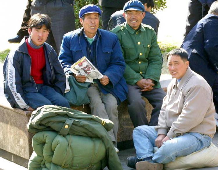 China's household registration system, which restricts movement within China according to place of birth, is central to government plans and will not be abolished. Migrants rest outside a railway station in Beijing in 2002, as they arrive back from their home provinces after the Lunar New Year. (GOH CHAI HIN/AFP/Getty Images)