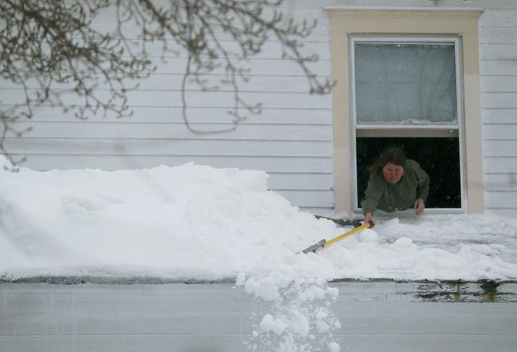 Peggy Grace pushes snow off of her roof on February 10, 2010 in Owings, MD. (Mark Wilson/Getty Images)