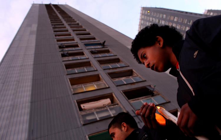 Vigil for three members of a Russian family who apparently committed suicide to avoid deportation, March 9, 2010. They jumped to their deaths from the 15th floor of Red Road flats, Glasgow, Scotland. (Jeff J Mitchell/Getty Images)