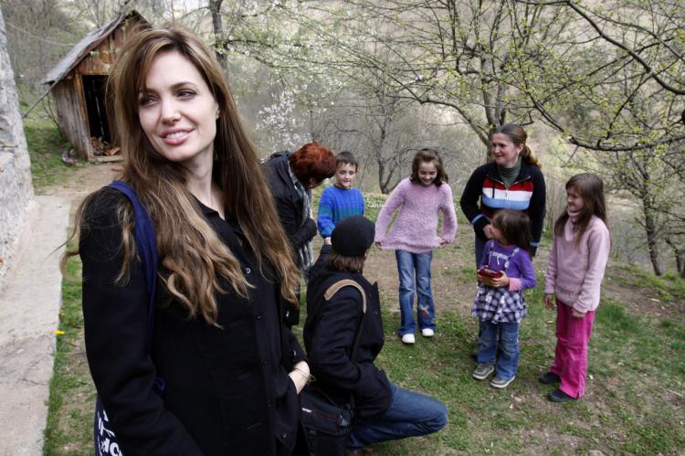 United Nations Refugee Agency goodwill ambassador Angelina Jolie (L) and Brad Pitt (3rdL in foreground) visit Bosnian Muslim refugee Sabina Karman (2ndL) and her four children, in the village of Medjedja, near the eastern Bosnian town of Visegrad on April (Amel Emric/AFP/Getty Images)