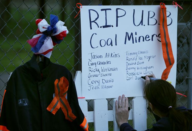 A women writes down the names of 29 fallen coal miners on a small memorial, on April 10, 2010 in Whitesville, West Virginia. On April 5, 29 coal miners were killed during a methane gas explosion at the Massey Energy Company's Upper Big Branch Coal Mine.  (Mark Wilson/Getty Images)