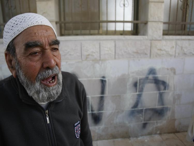 A Palestinian man stands in front of a star of David and Hebrew graffiti that was allegedly spray-painted by Jewish settlers on the wall of a mosque in the village of Hawara, near the West bank city of Nablus, on April 14, 2010. (Jaafar Ashtiyeh/AFP/Getty Images)