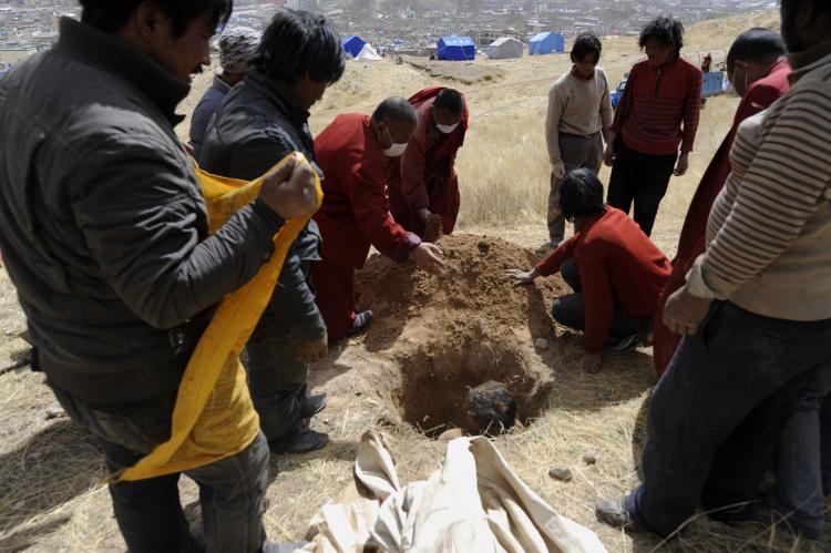 Tibetan Buddhist monks and civilians bury an earthquake victim on a hillside in Jiegu, Yushu county. ( Liu Jin/AFP/Getty Images)