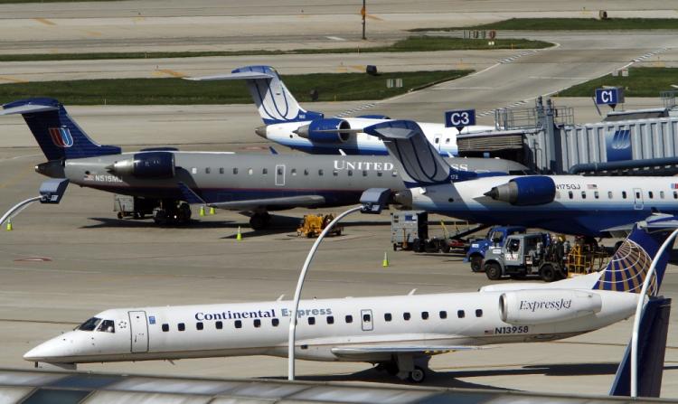Continental and United Airlines jets taxi to and from the gate at a gate at O'Hare International Airport May 3, 2010 in Chicago, Illinois.  (Frank Polich/Getty Images)