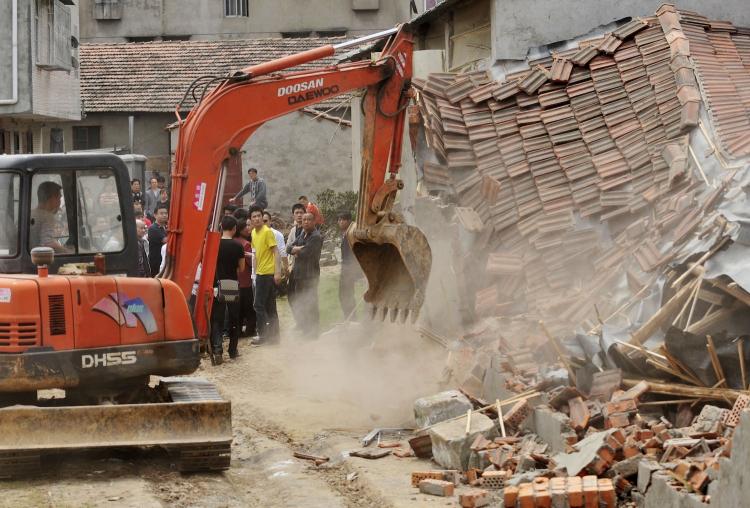 Chinese authorities carry sticks as they stand guard while workers demolish houses which are claimed illegal by the local government in Wuhan, central China's Hubei province on May 7, 2010. (AFP/Getty Images)