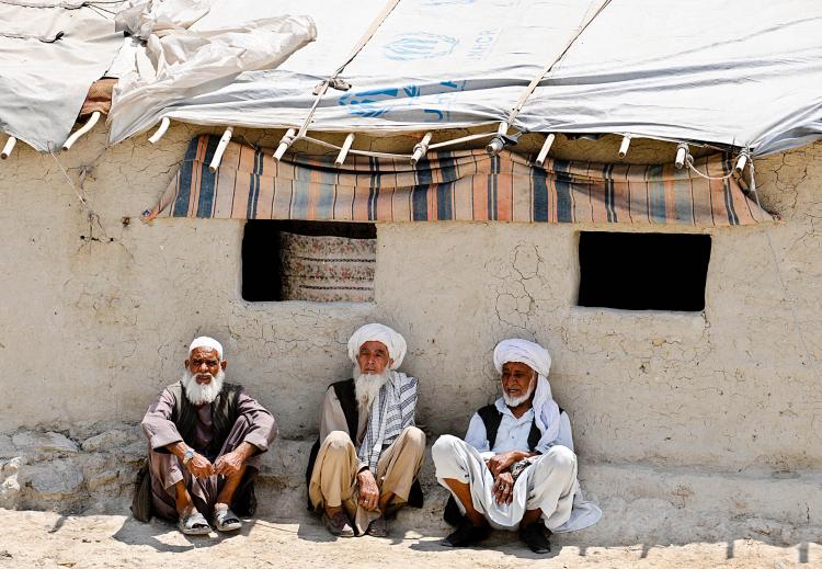 WAR CONTINUES: Elderly Afghan men sit outside mud shelters for the displaced in Kabul on July 7. (Shah Mari/Getty Images)