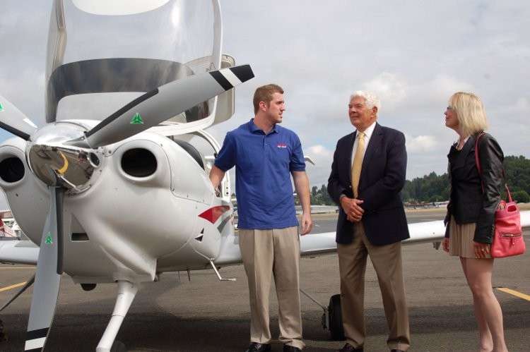 LANDING DOWN: Aviation High School donors James and Sherry Raisbeck welcome pilot and AHS inaugural class graduate Joey Marco after Marco arrived at the groundbreaking in a plane, which he piloted.  (The Keller Group)