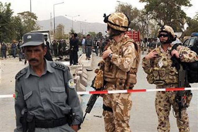 An Afghan policeman (L) with a British (C) and Australian soldier (R) at a roadblock where a suicide car bomb struck Italian vehicles killing six foreign soldiers from the NATO-led force in Kabul on September 17 2009. (SHAH MARAI/AFP/Getty Images)