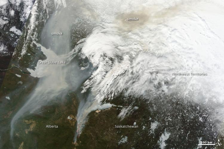 A satellite map from NASA's Eath Observatory shows tan and gray smoke spanning hundreds of miles across Alberta, Saskatchewan, and Northwest Territories on Monday. (NASA)