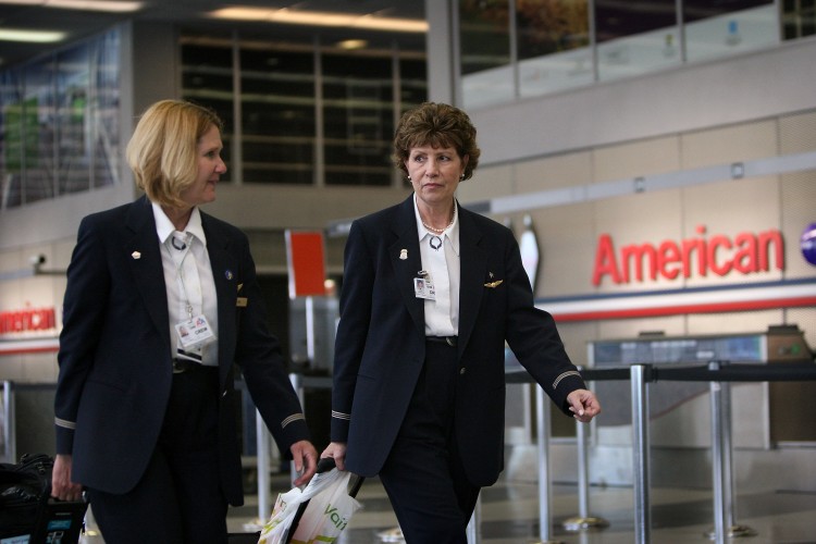 In this file photo, American Airlines flight attendants arrive at O'Hare International Airport in Chicago. American has signed nondisclosure agreements with US Airways and IAG to explore possible merger and/or financial stakes. (Scott Olson/Getty Images)