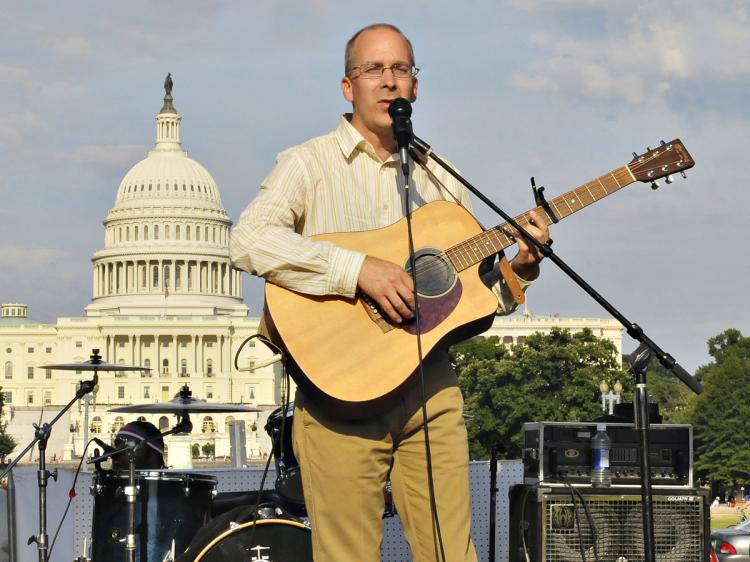 Anders Erikson sang and played for freedom in China during a concert at the National Mall in Washington, D.C. on July 19. (Khosro Zabihi/The Epoch Times)