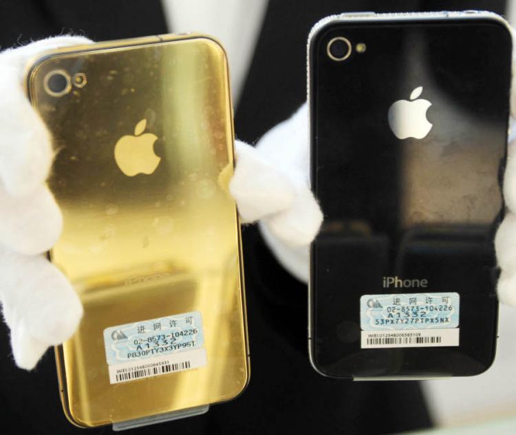 A shopkeeper shows golden accessories of Iphone at a shopping mall on March 25, 2011 in Qingdao, China.  (ChinaFotoPress/Getty Images)