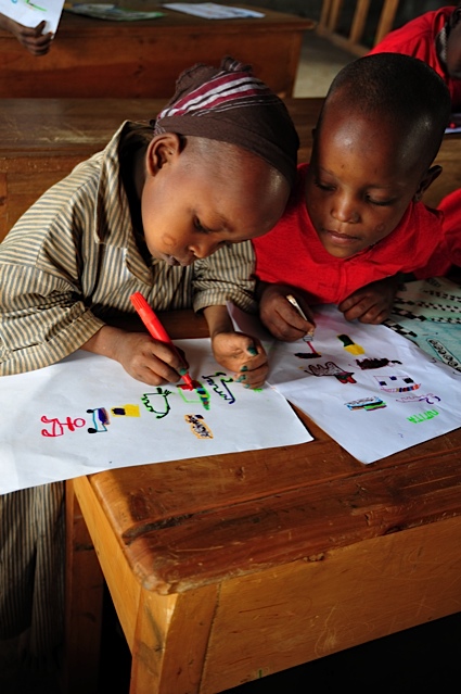 Students create art for their pen pals in England. The local primary school has received funding from the beadwork sales of the village women and is being assisted by ASK to improve the curriculum. (Courtesy of ASK)