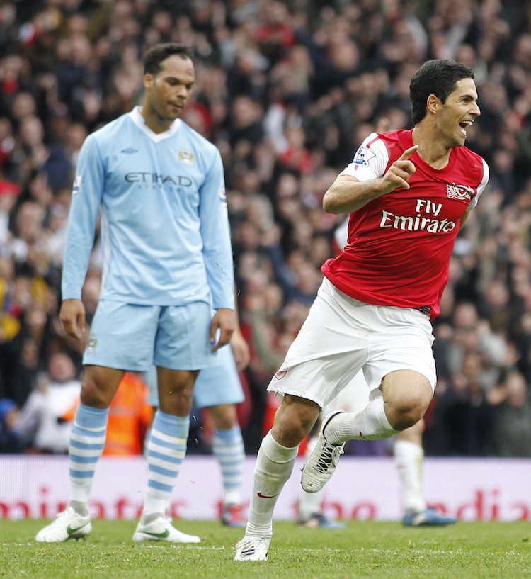 Arsenal's Mikel Arteta celebrates his winning goal as Manchester City's Joleon Lescott looks on glumly. (Ian Kington/AFP/Getty Images) 