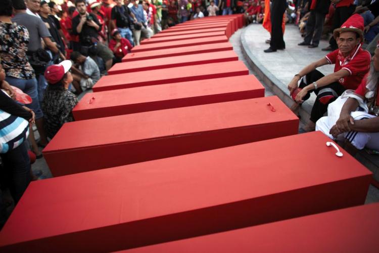 Red Shirt protesters gather around symbolic coffins during a memorial ceremony for the victims of clashes with Thai security forces near Democracy Monument on April 11, in Bangkok. (Athit Perawongmetha/Getty Images)