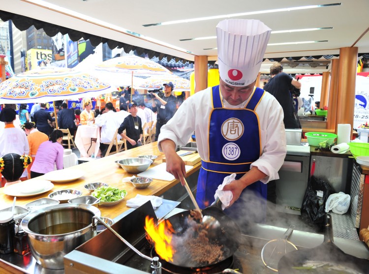 A chef cooks an authentic Chinese dish in Times Square during the 2011 International Chinese Culinary Competition. This September, celebrity chefs will join Chinese chefs in firing up their woks in Times Square.  (Dai Bing/The Epoch Times) 