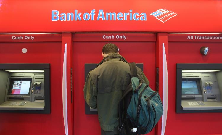 A man stands in a Bank of America ATM branch in New York City. Bank of America is the defendant in a class-action lawsuit alleging that the company failed to pay proper overtime wages in several jurisdictions.  ( Mario Tama/Getty Images)