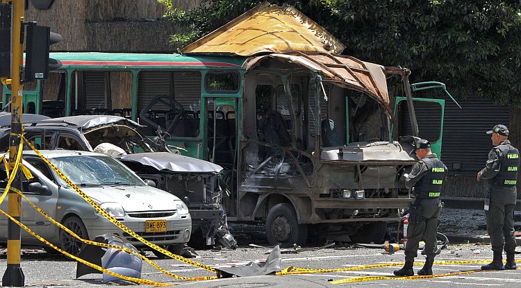 Police officers inspect the wreckage of vehicles after an explosion ripped through a crowded area of Bogota