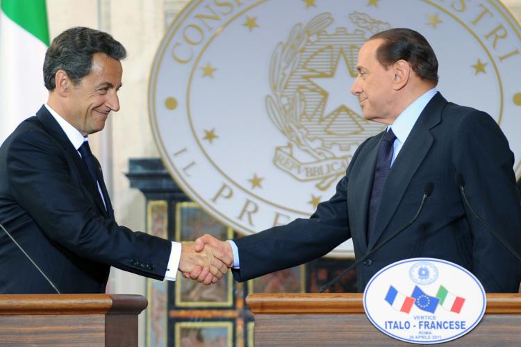 COMMON CAUSE: French President Nicolas Sarkozy and Italian Prime Minister Silvio Berlusconi (R) shake hands at the end of a summit on April 26 in Rome. The two leaders are spearheading a call to allow EU member states to reimpose internal border controls more easily. (Andreas Solaro/Getty Images )