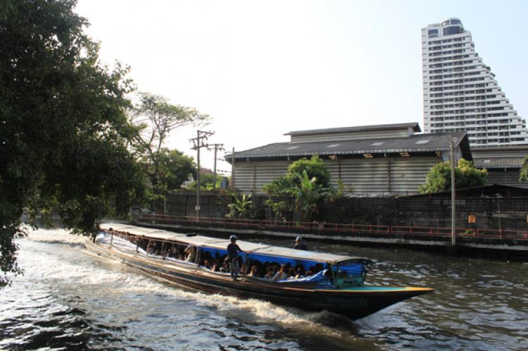 A Bangkok boat ferries Thai workers along a decent sized canal.
