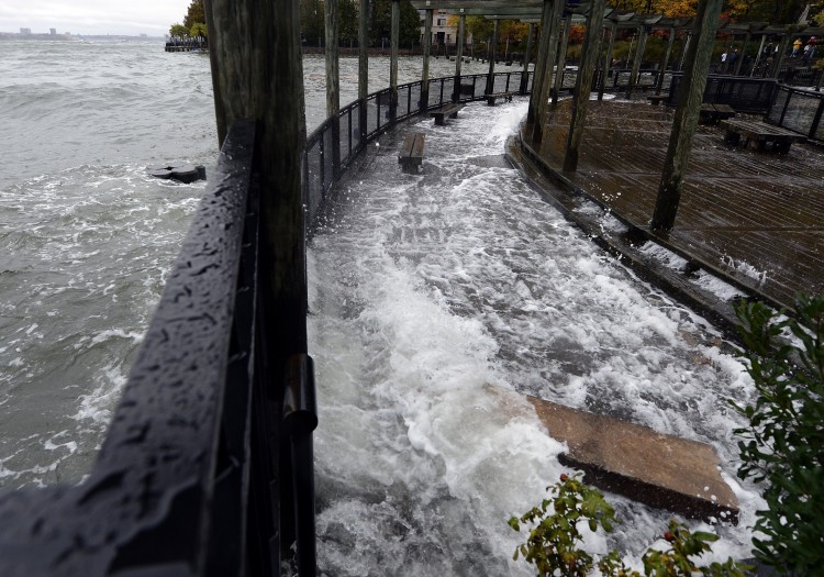 The Hudson River comes over the sea wall along the West Side Promenade in the Battery Park area in New York on Monday. (TIMOTHY A. CLARY/AFP/Getty Images)